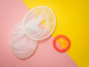 Na imagem, o preservativo branco é uma camisinha feminina, enquanto o laranja é a camisinha masculina. Crédito: Reproductive Health Supplies Coalition/Unsplash